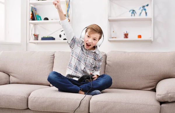 Teenage boy play games on sofa at home