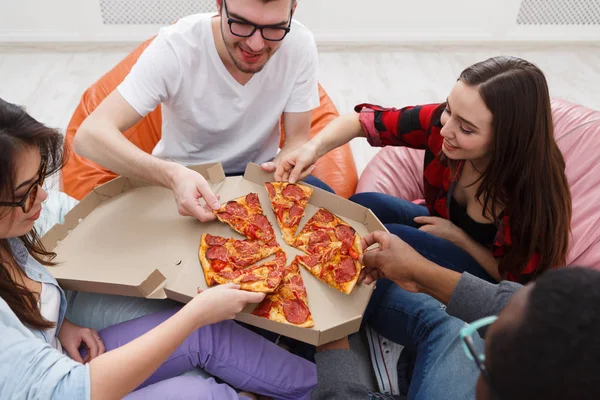 Students sharing pizza at home party