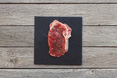 Ham sığır eti biftek koyu ahşap masa arka planda, üstten görünüm