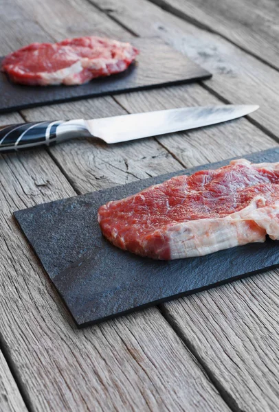 Steak de boeuf cru sur fond de table en bois foncé — Photo