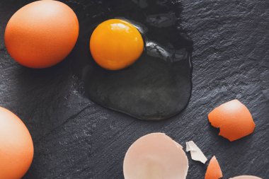 Brown organik yumurta sarısı siyah arka plan üzerine ile kırık