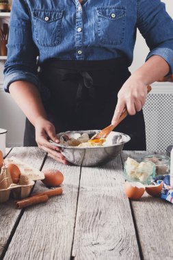Kadın baker karıştırın yumurta, tereyağı ve un ile hamur