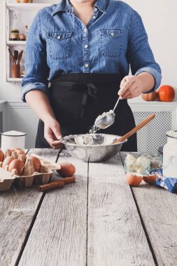 Kadın baker karıştırın yumurta, tereyağı ve un ile hamur