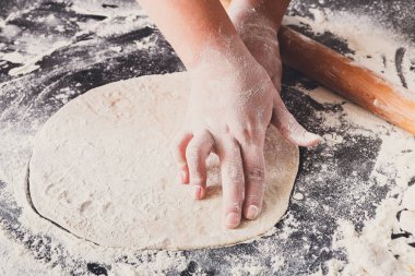 Fırın kavramı. El hamur siyah arka plan üzerine rulo..