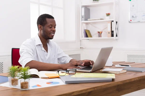 Νέοι μαύρο επιχειρηματίας που εργάζεται με το laptop στο μοντέρνο λευκό γραφείο — Φωτογραφία Αρχείου