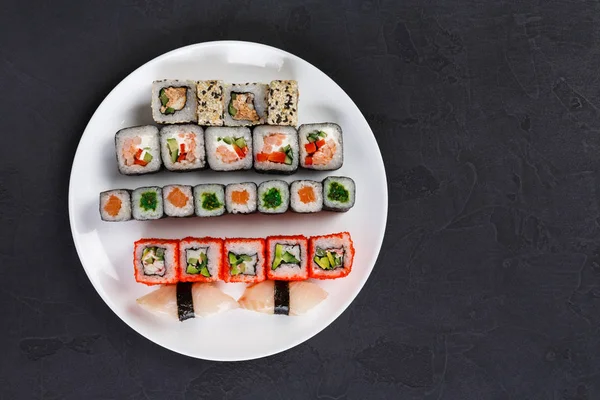 Set sushi en broodjes op zwarte achtergrond, bovenaanzicht — Stockfoto