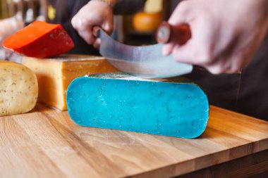 Gouda pesto mavi peynir bakkal dükkanında kesme