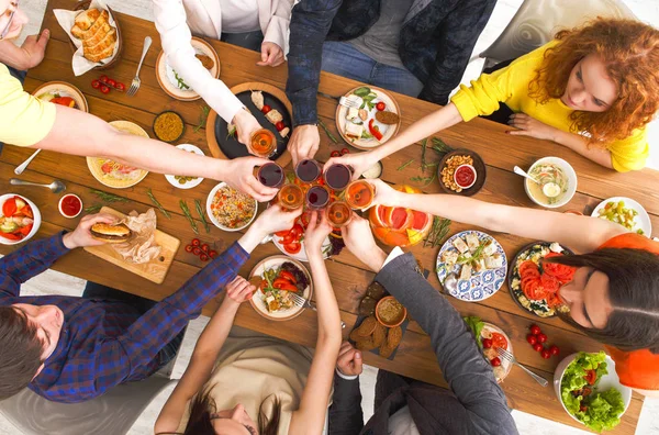 People say cheers clink glasses at festive table dinner party