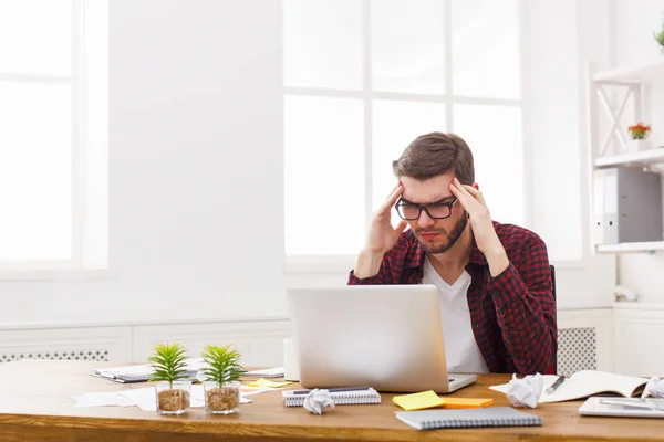 Young benadrukt zakenman met laptop in moderne witte kantoor — Stockfoto