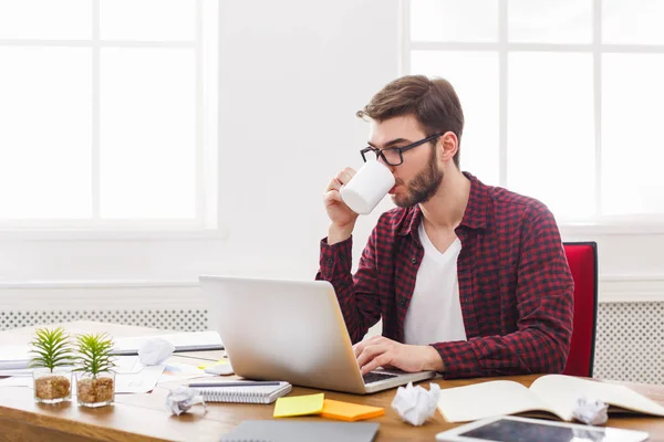 Jeune homme d'affaires travaillant avec un ordinateur portable dans un bureau blanc moderne — Photo