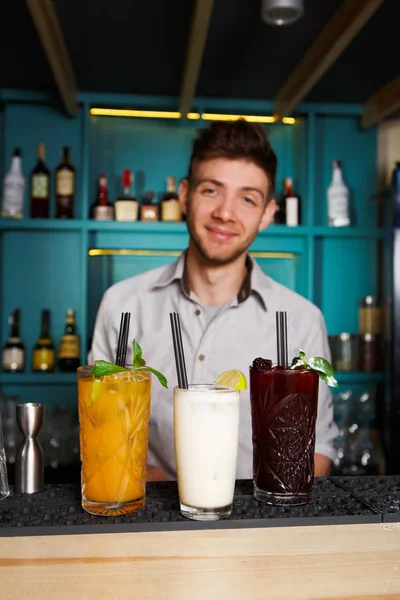 Young Barman ofrece cócteles de alcohol en el bar del club nocturno — Foto de Stock