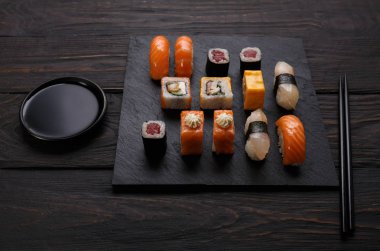 Siyah ahşap üzerine Japon restoranı Sushi ve rulo ayarla