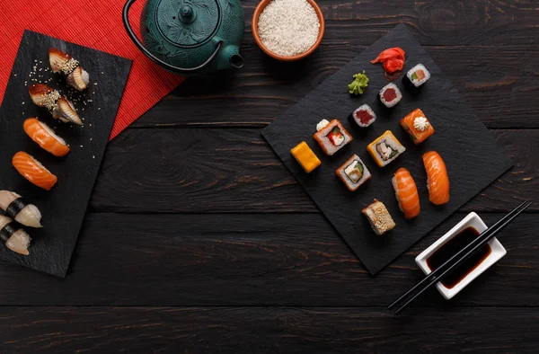 Sushi und Semmeln Hintergrund, Rahmen auf Schwarz, Draufsicht. — Stockfoto