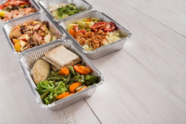 Alimentos saudáveis levam em caixas de papel alumínio sobre fundo de madeira — Fotografia de Stock