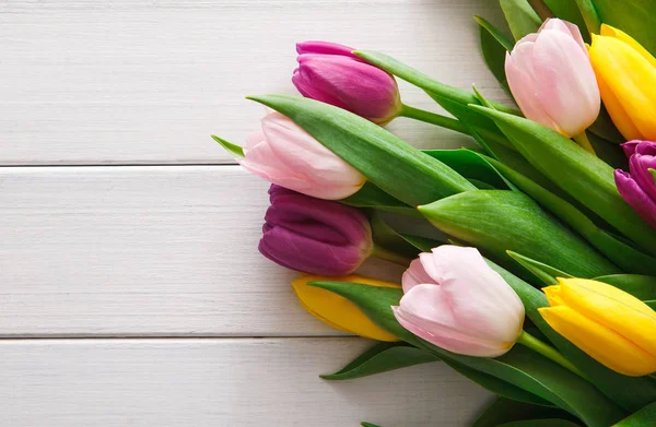 Luminoso bouquet di tulipani su sfondo in legno bianco, copiare spazio — Foto Stock