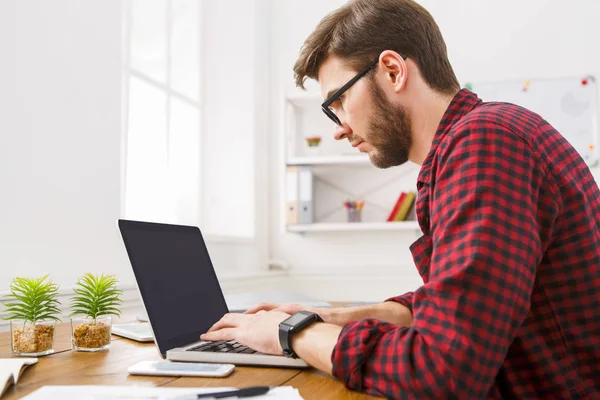 Jovem empresário trabalhando com laptop no escritório branco moderno — Fotografia de Stock