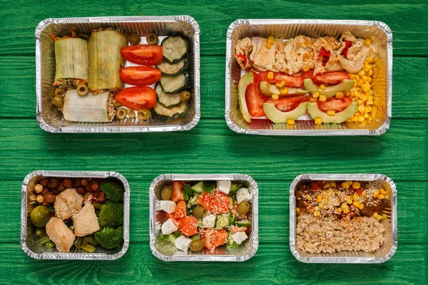 Alimentos saudáveis levam em caixas, vista superior em madeira verde — Fotografia de Stock