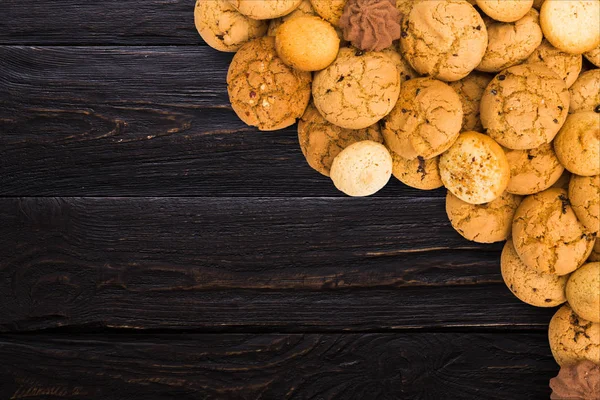 Biscoitos e biscoitos em madeira preta com espaço de cópia — Fotografia de Stock