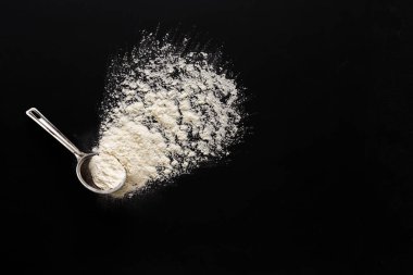 Kaşık ölçüm siyah arka plan üzerine un