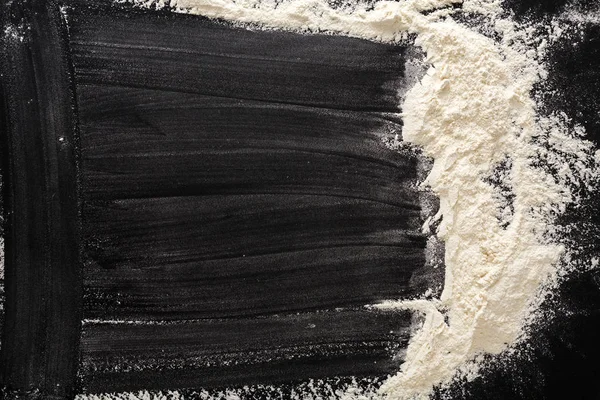 Concepto de cocción sobre fondo negro, harina espolvoreada con espacio para copiar — Foto de Stock