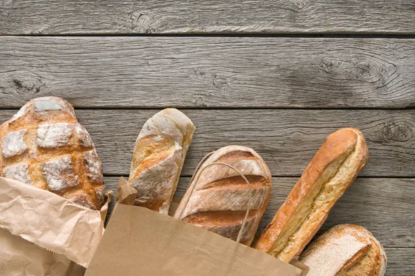 Panadería de pan fondo. Composición de los panes de trigo integral y blanco sobre madera rústica — Foto de Stock
