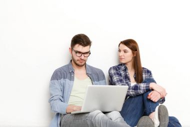 Dizüstü bilgisayar kullanan adam yanında oturan kadın sıkıcı