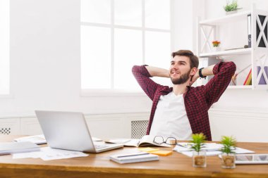 Genç işadamı modern beyaz ofis içinde laptop ile rahat