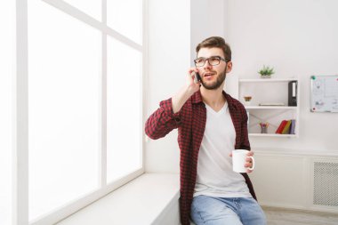 Kendine güvenen genç işadamı ofis pencere yakınındaki