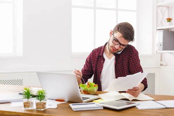 Drukke man heeft zakenlunch in moderne kantoor interieur — Stockfoto