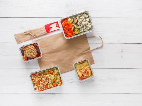 Daily meals delivery in foil containers top view on white wood. — Stock Photo, Image