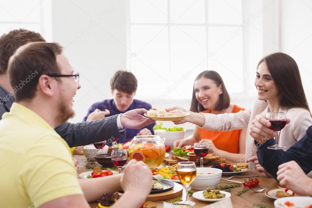 Group of happy people at festive table dinner party