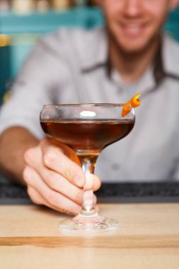 Genç barmen gece kulübü barda kokteylin alkol sunar