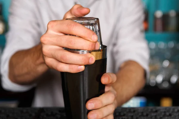 Barman en el bar sacudiendo y mezclando cóctel de alcohol, primer plano agitador — Foto de Stock