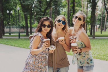 Üç güzel genç boho chic şık kız Parkta yürümek.