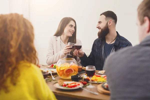 Group of happy young people at dinner table, friends party