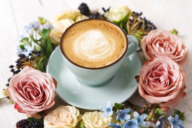 Beyaz ahşap cappuccino kahve ve çiçekler kompozisyonu