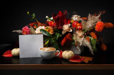 Siyah arka plan üzerine cappuccino kahve ve çiçek kompozisyon