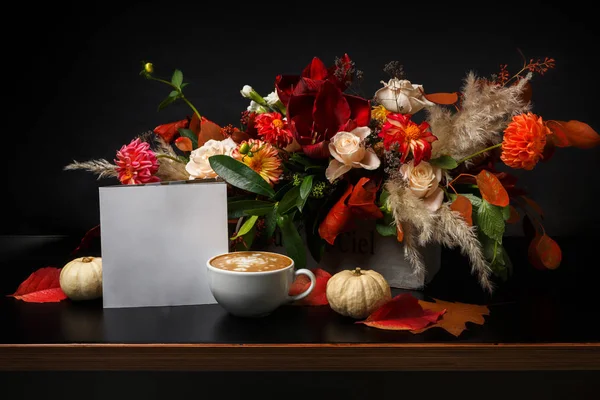 Siyah arka plan üzerine cappuccino kahve ve çiçek kompozisyon