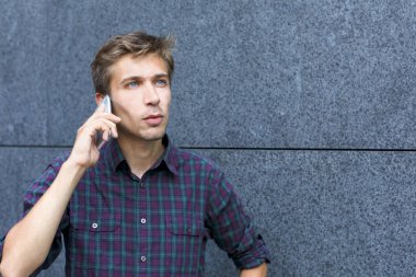 Telefon açık kopya alanı üzerinde konuşan genç adam