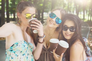 Üç güzel genç boho chic şık kız Parkta yürümek.