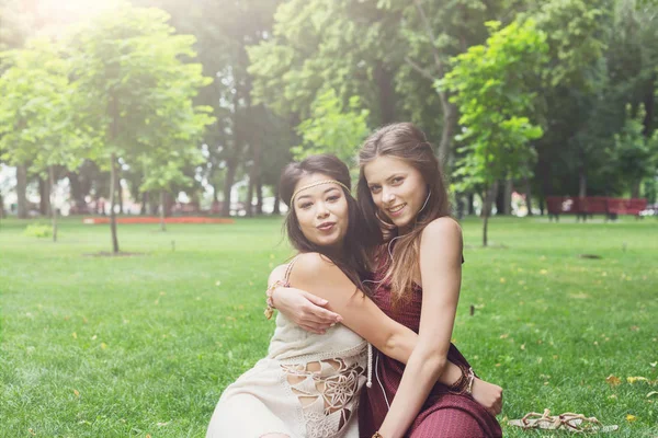 Две счастливые девушки обнимаются в летнем парке. — стоковое фото