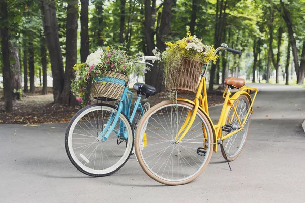 Amarelo e turqoise cidade mulher bicicletas com flores no parque — Fotografia de Stock
