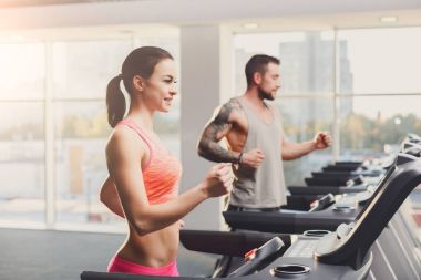 Erkek ve kadın, çift koşu bandı üzerinde spor salonunda