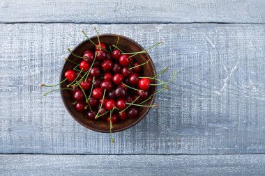 Mavi rustik ahşap üzerine yeşil yaprakları ile tatlı taze kiraz