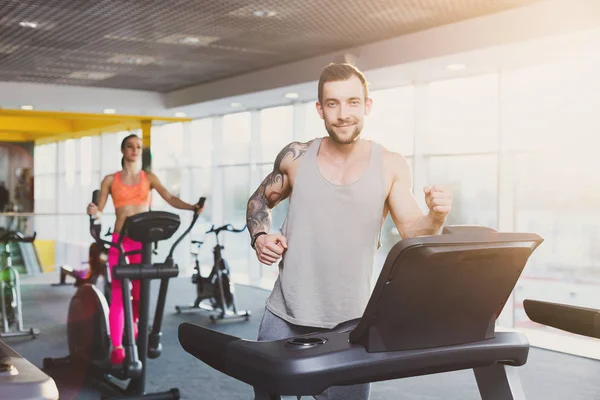 Joven en el gimnasio correr en la cinta de correr — Foto de Stock