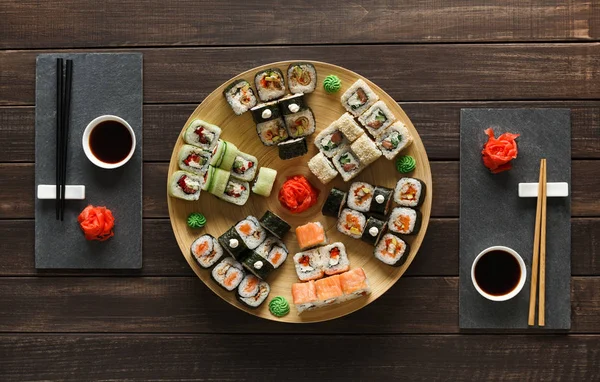 Σύνολο sushi maki και ρολά σε μαύρο ρουστίκ ξύλο, κορυφαία προβολή — Φωτογραφία Αρχείου