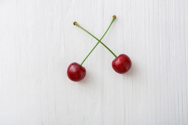 Cerises fraîches sucrées sur fond de bois blanc — Photo