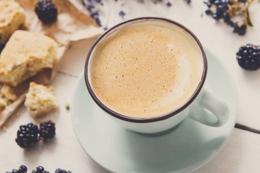 Beyaz ahşap üzerine sütlü kahve ve çiçek kompozisyon