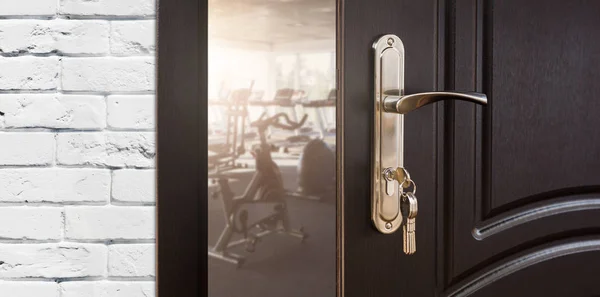 Vchod do tělocvičny ve fitness klubu, otevřené dveře s rotopedy — Stock fotografie