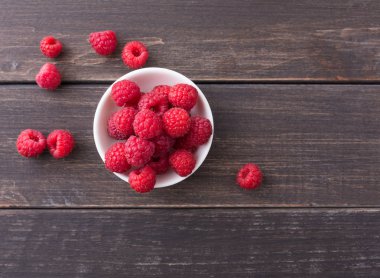 Beyaz rustik ahşap arka plan üzerinde kırmızı taze frambuaz